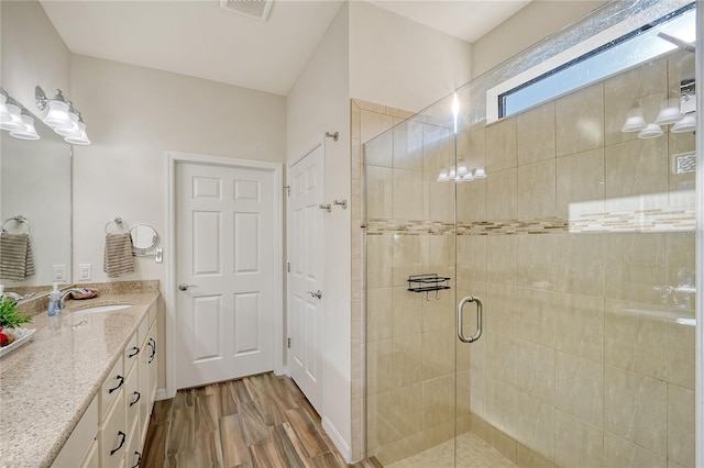 bathroom featuring vanity, hardwood / wood-style flooring, and a shower with shower door