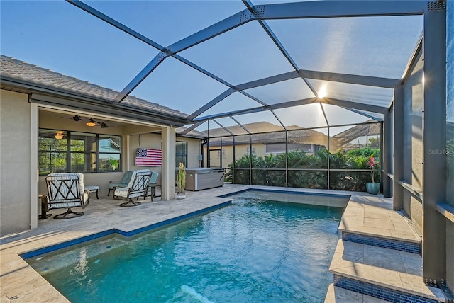 view of pool with ceiling fan, a patio area, a lanai, and a hot tub