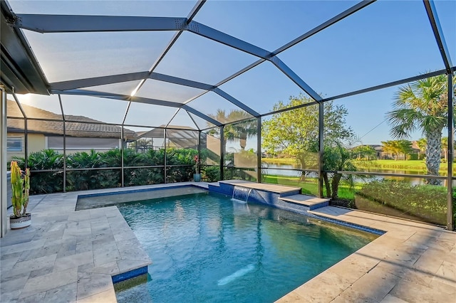 view of pool with glass enclosure, pool water feature, a patio area, and a water view