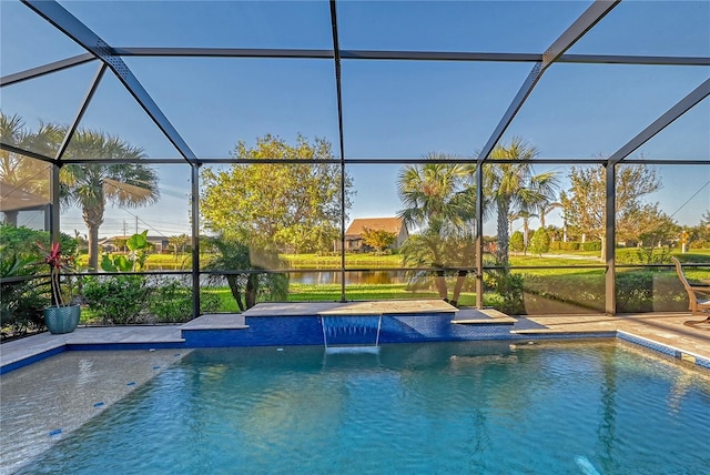 view of swimming pool with glass enclosure, pool water feature, and a water view