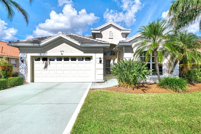 view of front of home with a garage and a front lawn