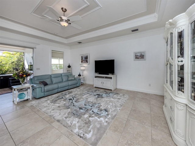 tiled living room with a tray ceiling, ceiling fan, and ornamental molding