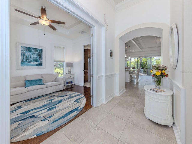 hall featuring light tile patterned floors, crown molding, a wealth of natural light, and coffered ceiling