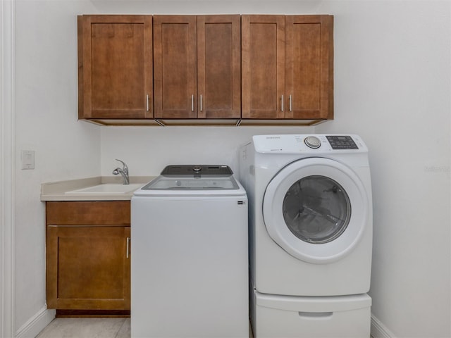 washroom with washer and dryer, cabinets, light tile patterned floors, and sink