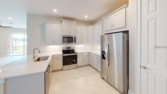 kitchen with stainless steel appliances, white cabinetry, sink, kitchen peninsula, and tasteful backsplash