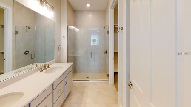 bathroom with a shower with door, vanity, and tile patterned floors