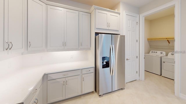 kitchen with white cabinetry, stainless steel fridge with ice dispenser, and washing machine and clothes dryer