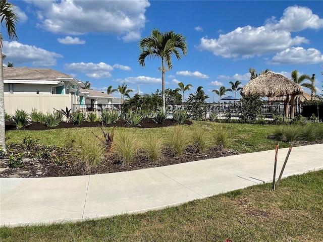 view of community with fence and a lawn