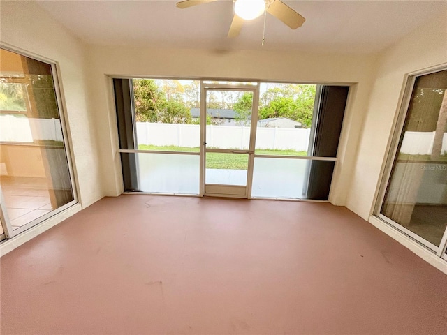 unfurnished sunroom with ceiling fan