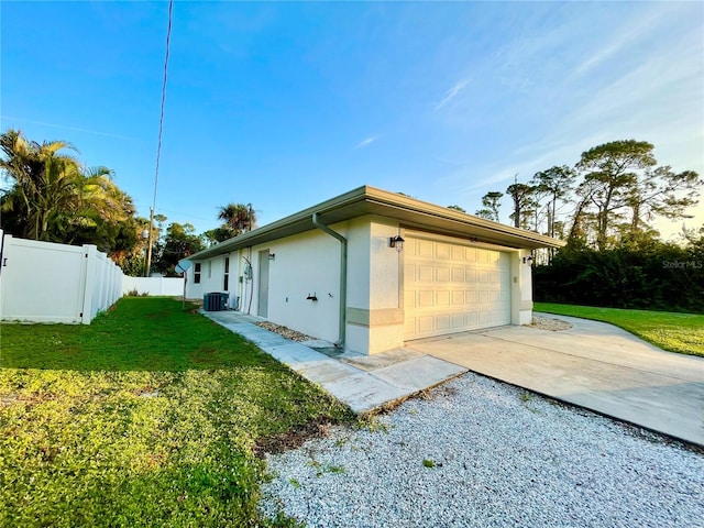 view of side of property with a garage, a lawn, and central air condition unit