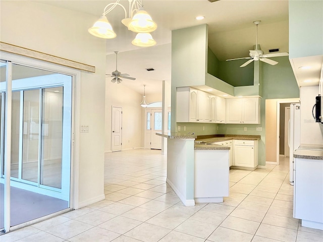 kitchen featuring white refrigerator, white cabinets, ceiling fan, and kitchen peninsula