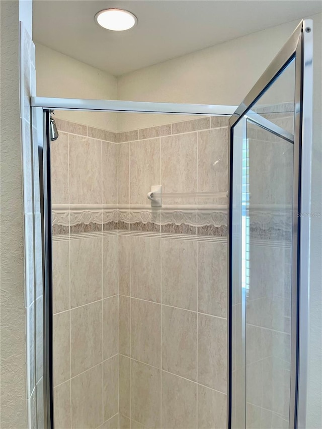 bathroom featuring a shower with door