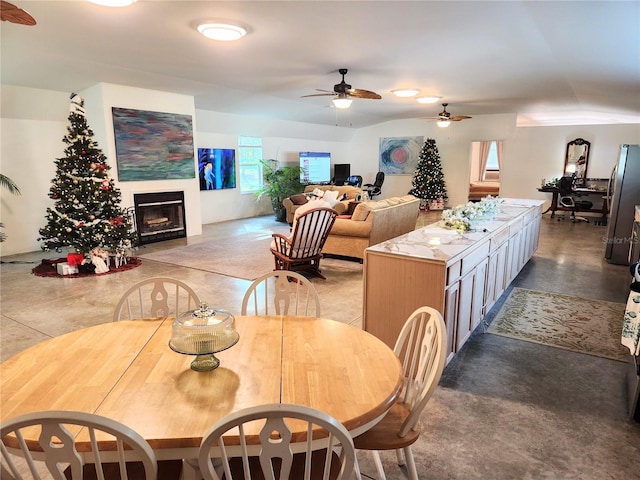 dining space featuring concrete floors and ceiling fan