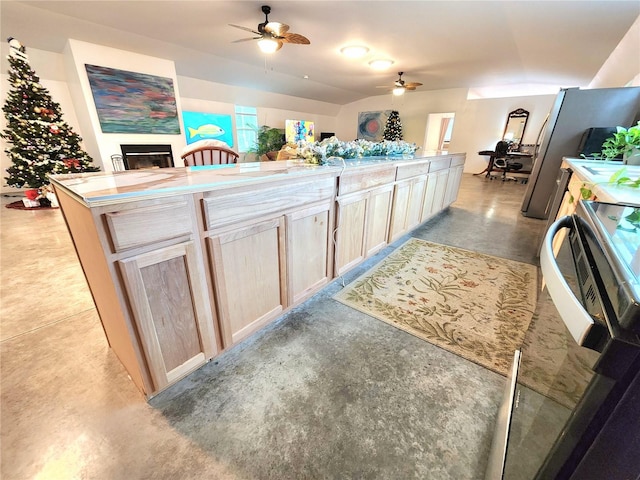 kitchen with ceiling fan, light brown cabinetry, and stainless steel stove