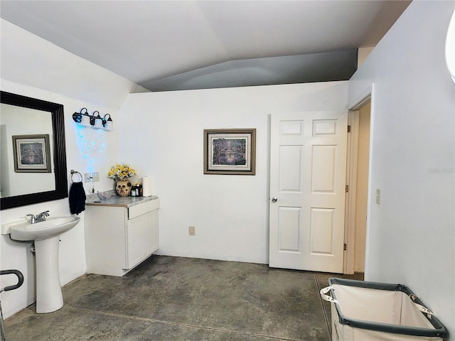 bathroom featuring sink, concrete floors, and lofted ceiling