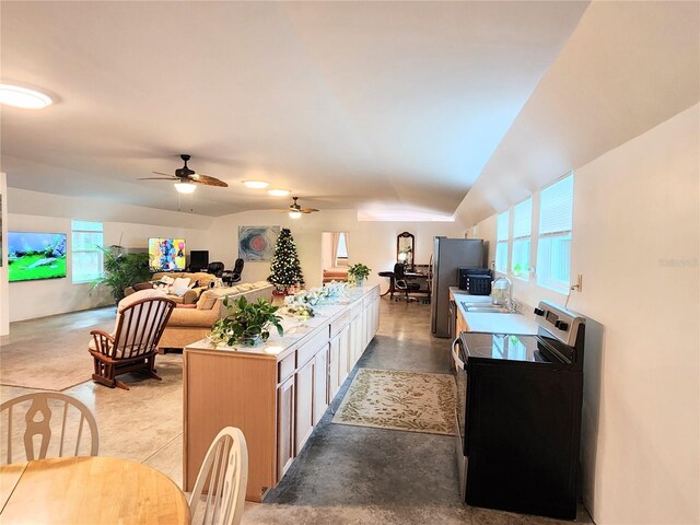 kitchen featuring ceiling fan, sink, black electric range oven, stainless steel fridge, and vaulted ceiling