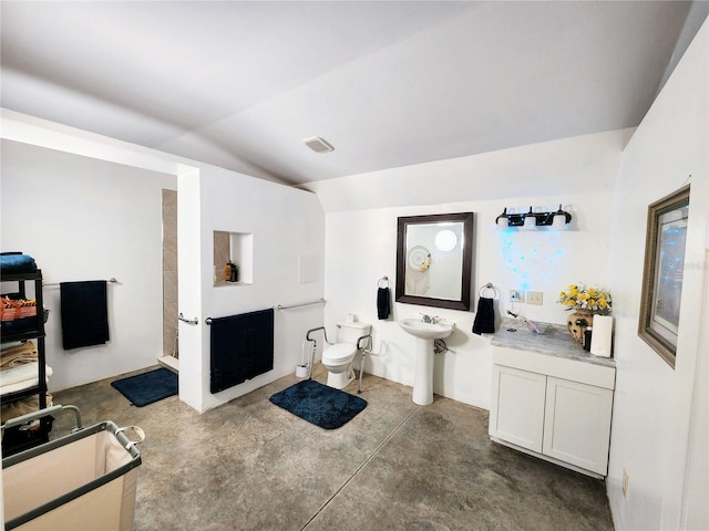 bathroom featuring sink, concrete floors, vaulted ceiling, and toilet