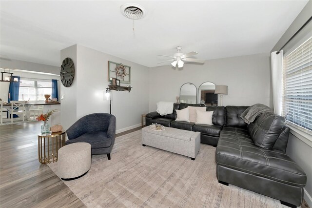 living room with ceiling fan and light hardwood / wood-style flooring