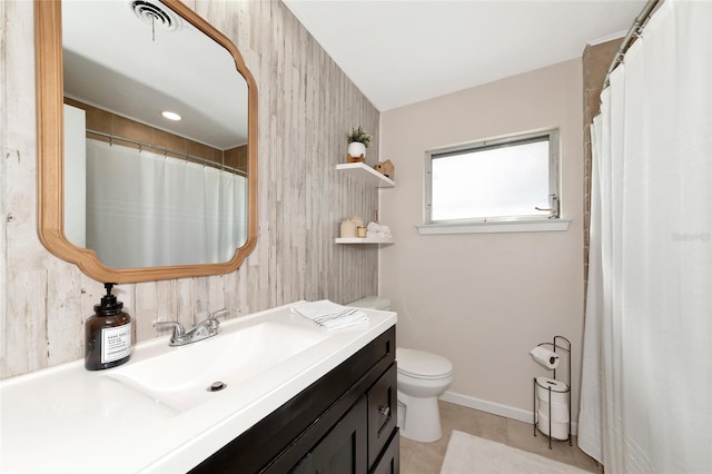 bathroom featuring tile patterned floors, vanity, wooden walls, and toilet