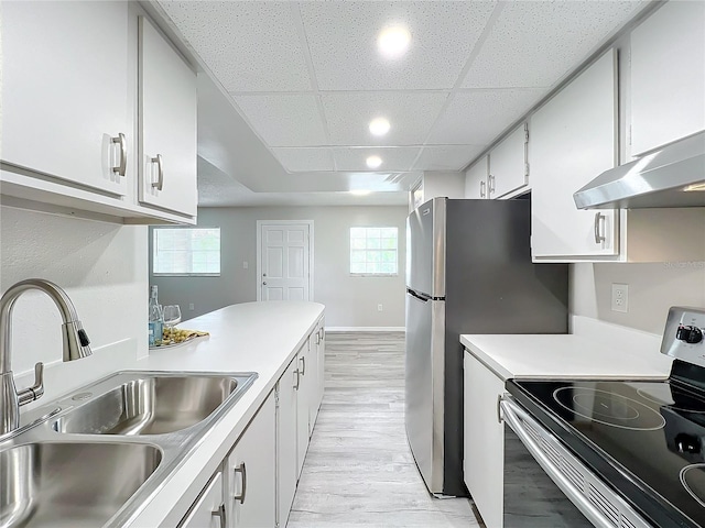 kitchen featuring a paneled ceiling, stainless steel appliances, sink, white cabinetry, and plenty of natural light