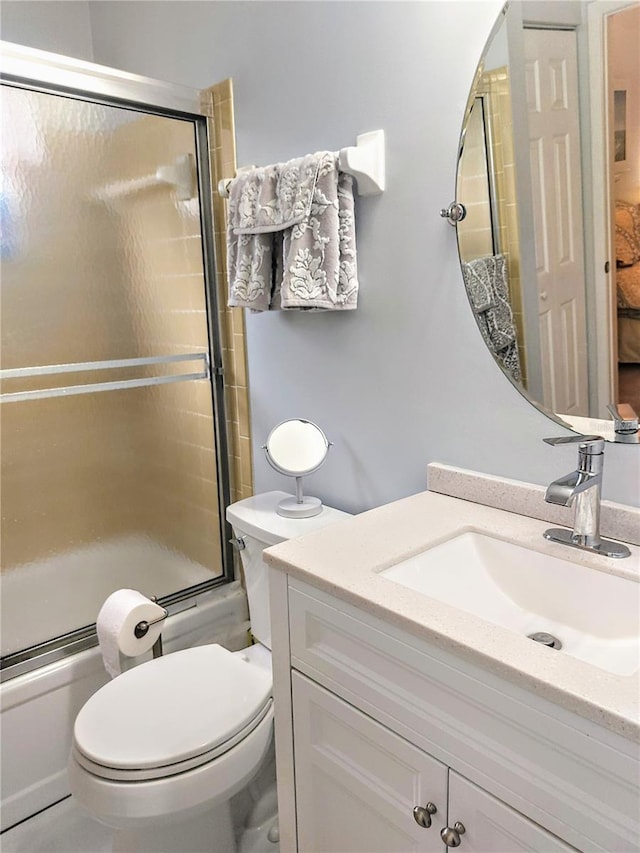 full bathroom with toilet, vanity, and combined bath / shower with glass door