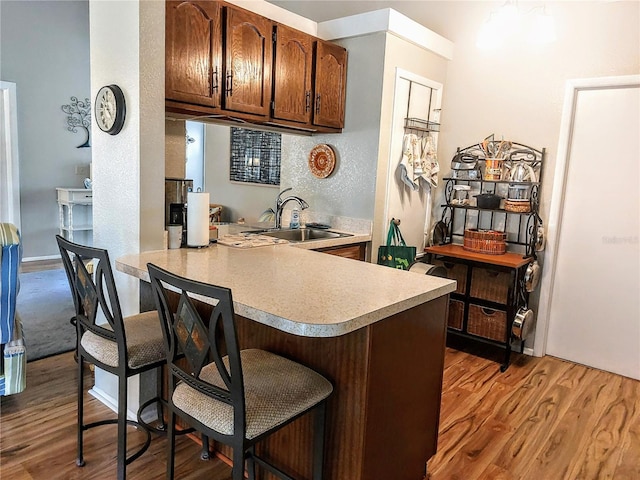 kitchen featuring kitchen peninsula, dark hardwood / wood-style flooring, and sink