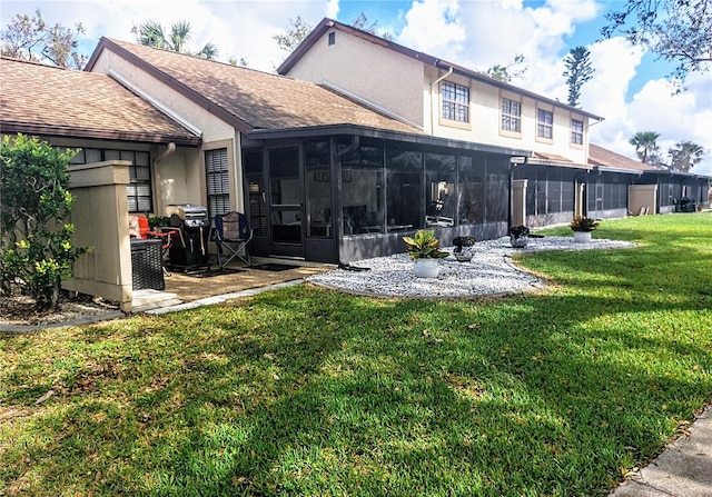 back of house with a yard and a sunroom