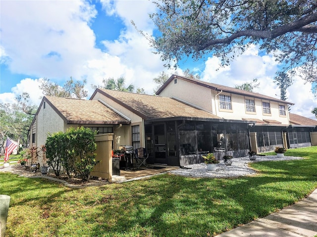 rear view of property featuring a sunroom and a yard