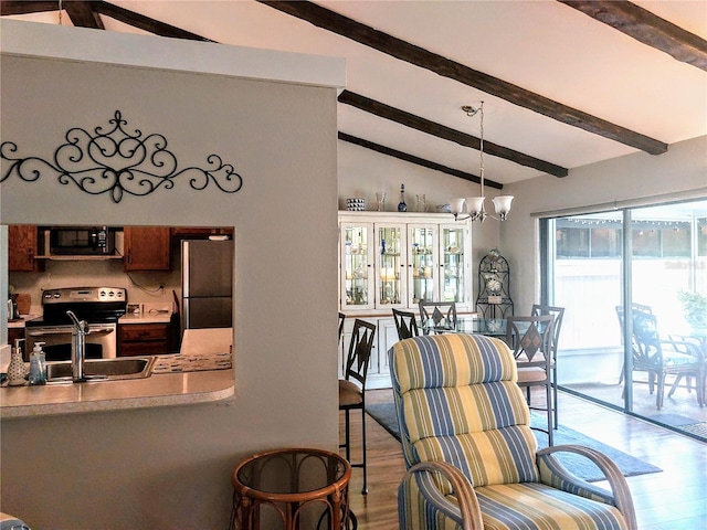 dining area with a chandelier, vaulted ceiling with beams, light hardwood / wood-style flooring, and sink