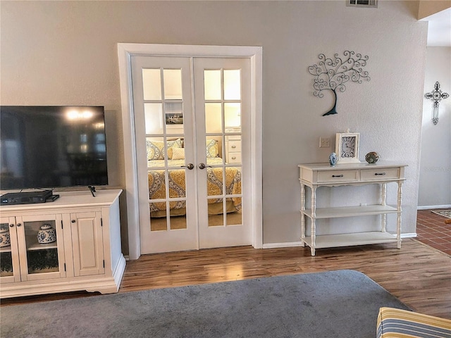 doorway with dark hardwood / wood-style floors and french doors