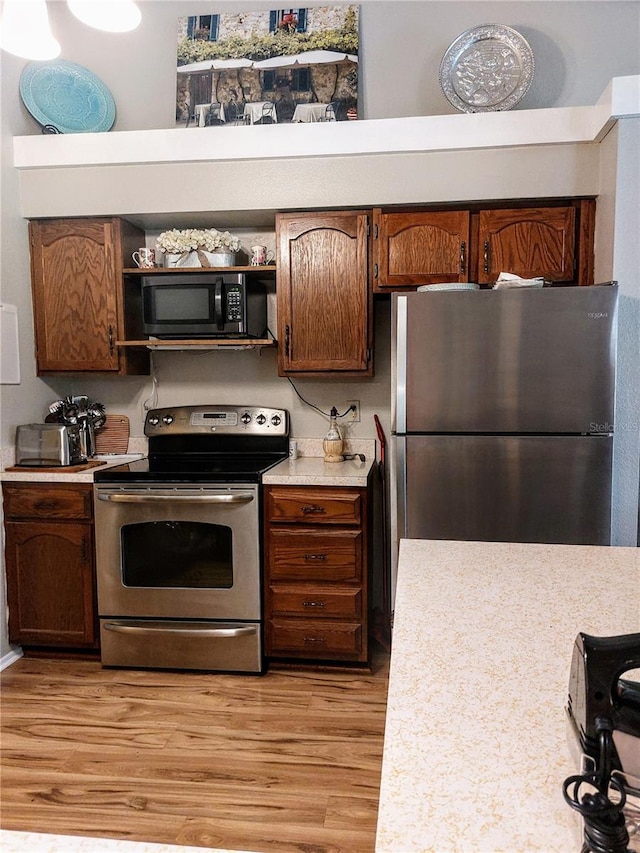 kitchen with light hardwood / wood-style flooring and appliances with stainless steel finishes