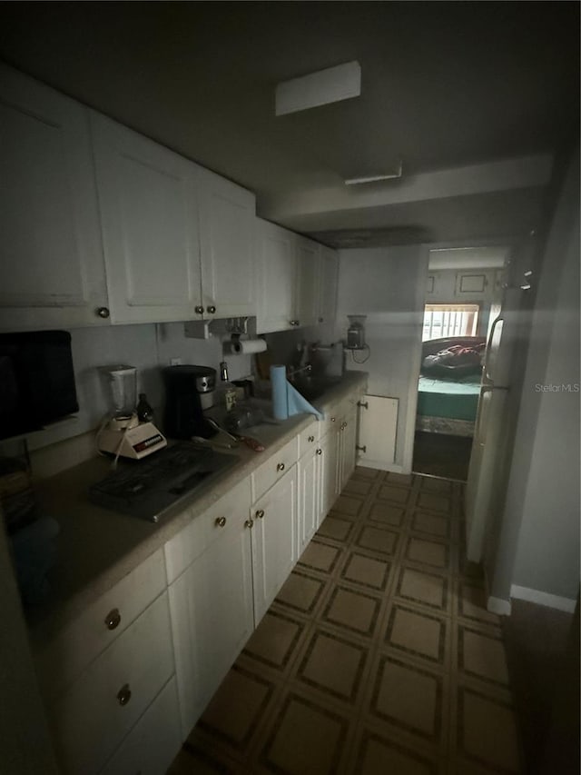 kitchen featuring white cabinetry and fridge