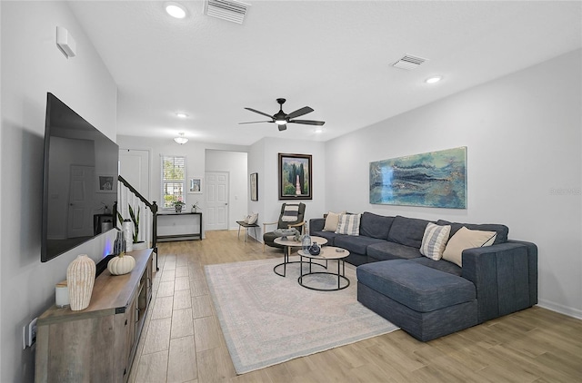 living room with ceiling fan and light wood-type flooring