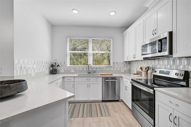 4008 Via Sienna Cir, Sarasota, FL 34243 - kitchen with stainless steel appliances, a sink, white cabinetry, light stone counters, and recessed lighting
