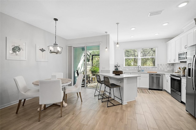 4008 Via Sienna Cir, Sarasota, FL 34243 - kitchen featuring stainless steel appliances, healthy amount of natural light, light countertops, a kitchen bar, and recessed lighting