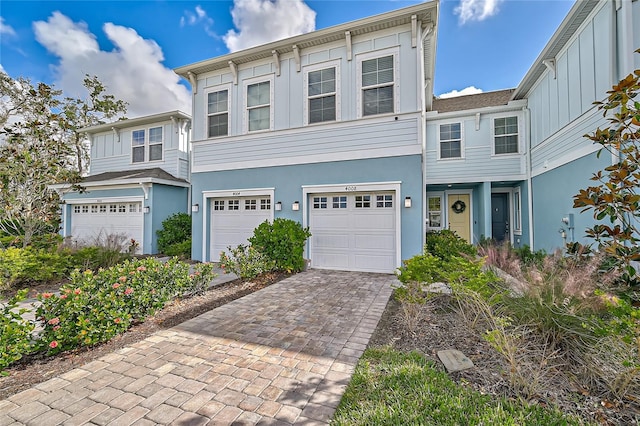 4008 Via Sienna Cir, Sarasota, FL 34243 - view of front of house with a garage, stucco siding, decorative driveway, and board and batten siding