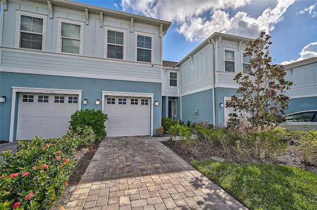 4008 Via Sienna Cir, Sarasota, FL 34243 - view of front of home featuring stucco siding, decorative driveway, a garage, and board and batten siding