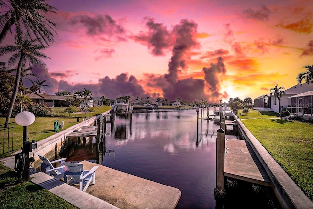 view of dock featuring a water view and a yard