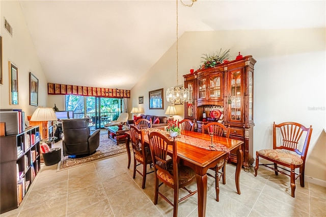 dining area featuring high vaulted ceiling and a notable chandelier