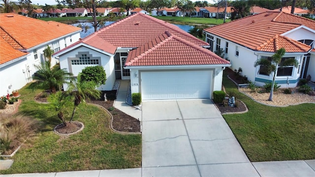 mediterranean / spanish-style house featuring a garage, a water view, and a front yard