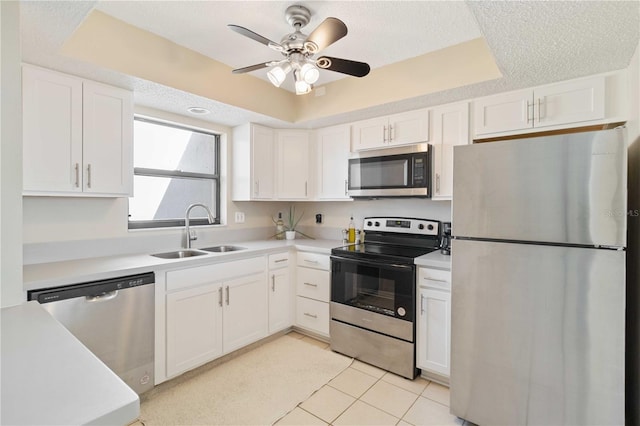 kitchen featuring white cabinetry, appliances with stainless steel finishes, a textured ceiling, light tile patterned floors, and sink