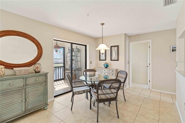 dining room featuring a textured ceiling and light tile patterned floors