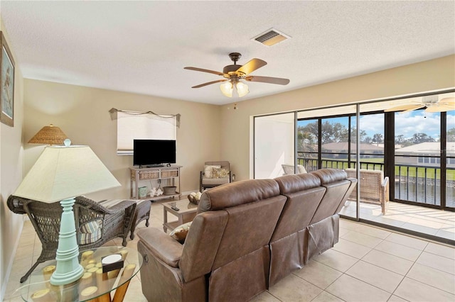 tiled living room with a textured ceiling and ceiling fan