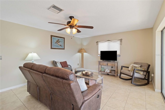 tiled living room with a textured ceiling and ceiling fan