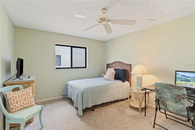 bedroom featuring a textured ceiling, light colored carpet, and ceiling fan