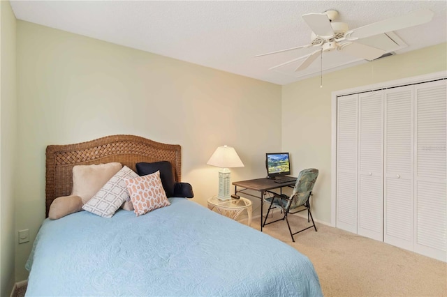 bedroom featuring light colored carpet, ceiling fan, and a closet