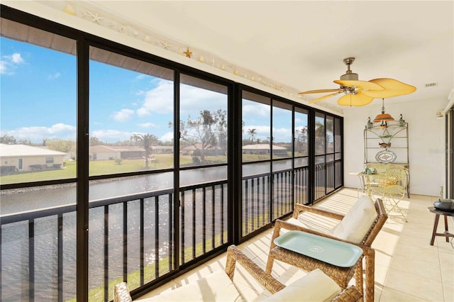 sunroom featuring a water view and ceiling fan