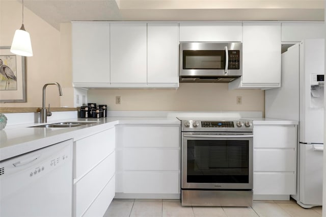 kitchen featuring white cabinets, hanging light fixtures, sink, appliances with stainless steel finishes, and light tile patterned flooring