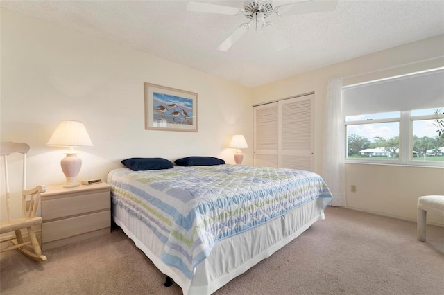 bedroom featuring ceiling fan, carpet floors, a textured ceiling, and a closet