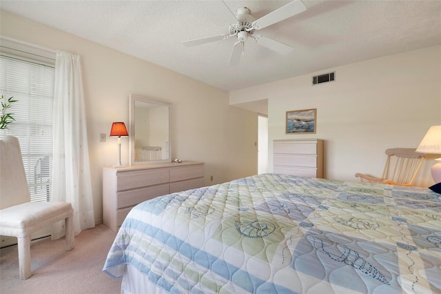 carpeted bedroom featuring ceiling fan and a textured ceiling